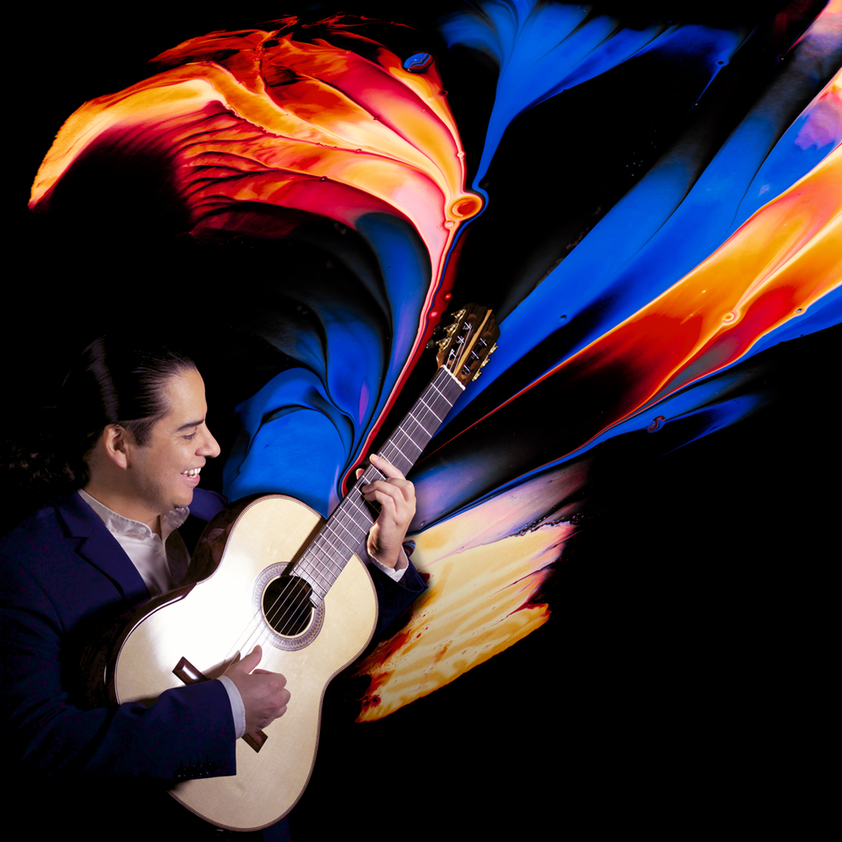 Ein Mann spielt Gitarre vor einem schwarzen Hintergrund, aus dem Instrument strömen bunte Farben.