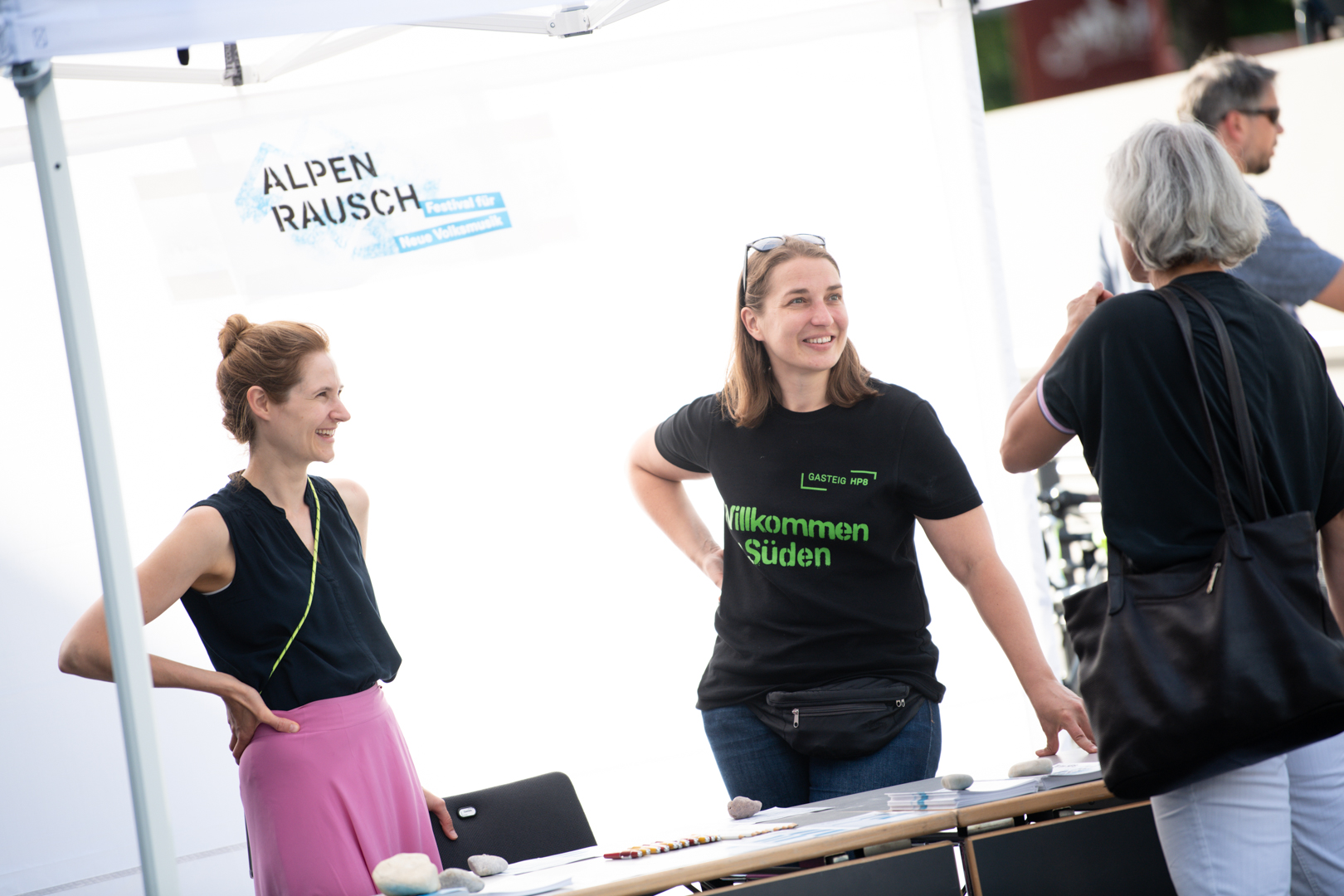 Two friendly Gasteig employees in an information tent talk to guests.