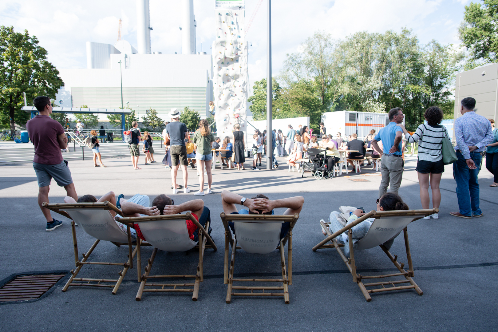 People lying in deck chairs with a view of the cogeneration plant