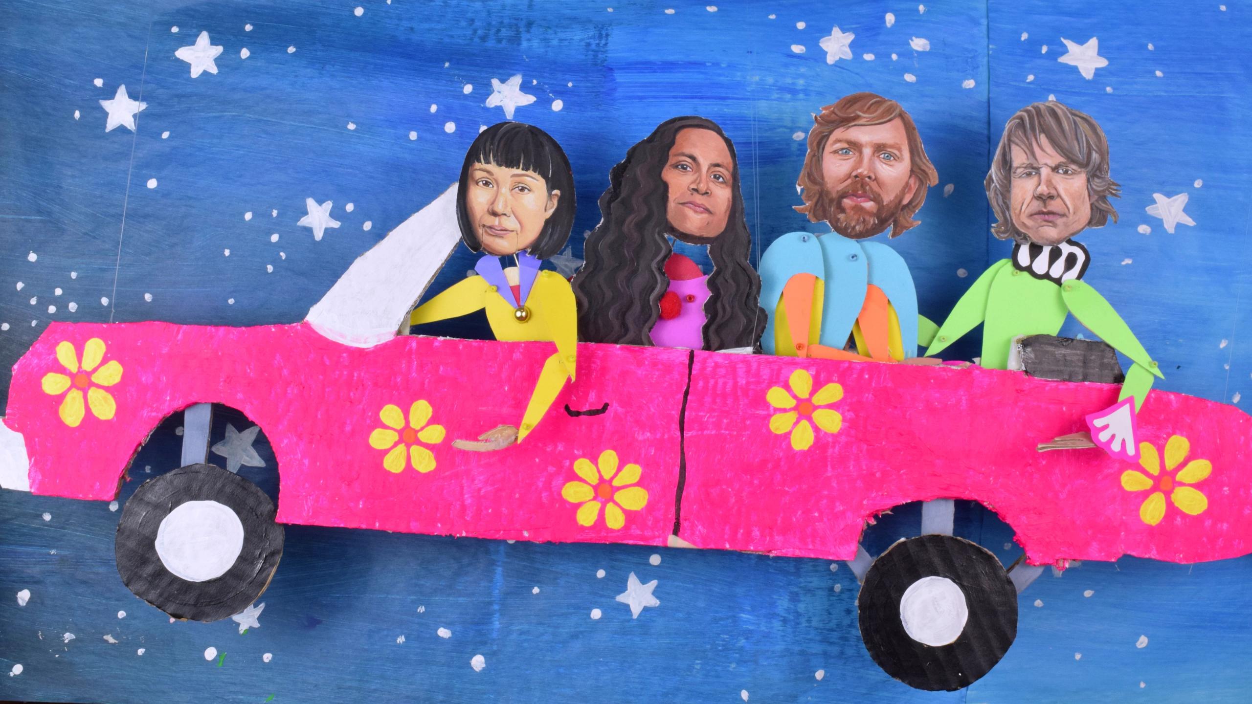 A collage of painted cardboard pictures. A pink convertible with yellow flowers against a blue background with white stars. In the car are two women and two men.