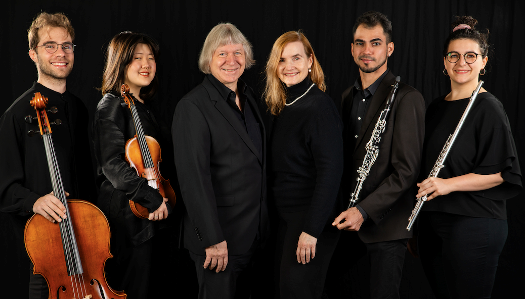 Six musicians in front of a black background.