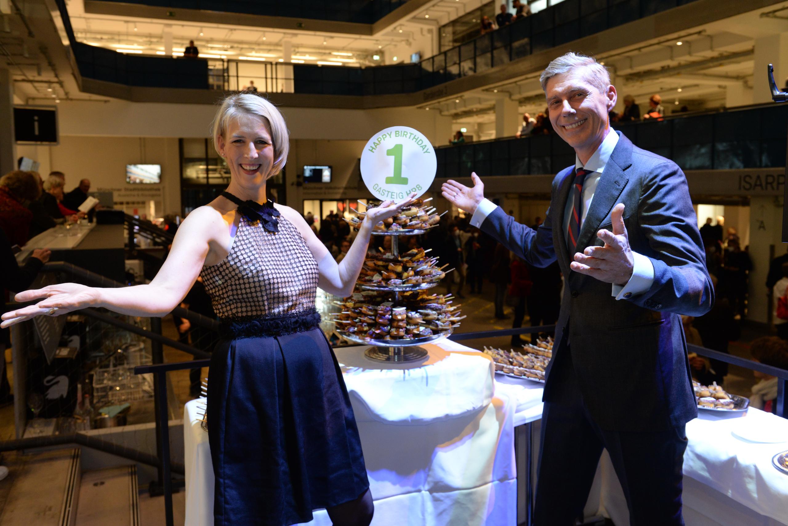 Katrin Habenschaden and Max Wagner stand smiling in front of a cake setup.