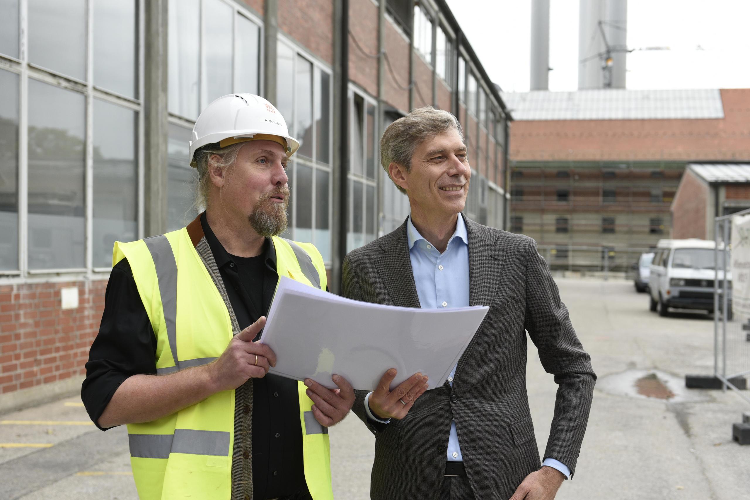 Lagebesprechung im Gasteig HP8: Bauleiter Andreas Schmidt und Gasteig-Chef Max Wagner besichtigen die Baustelle, den Bauplan halten sie gemeinsam in den Händen.