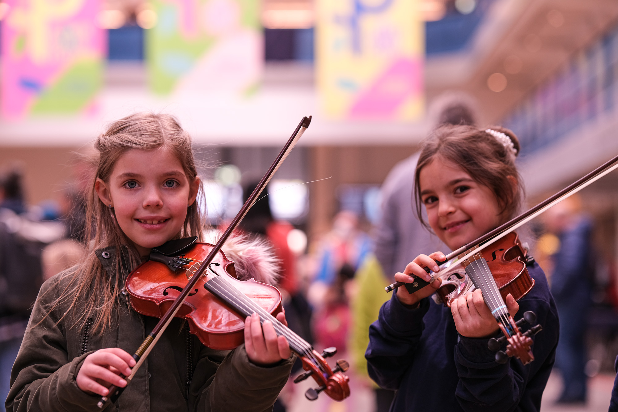Zwei Mädchen mit Geigen spielen in der Halle E