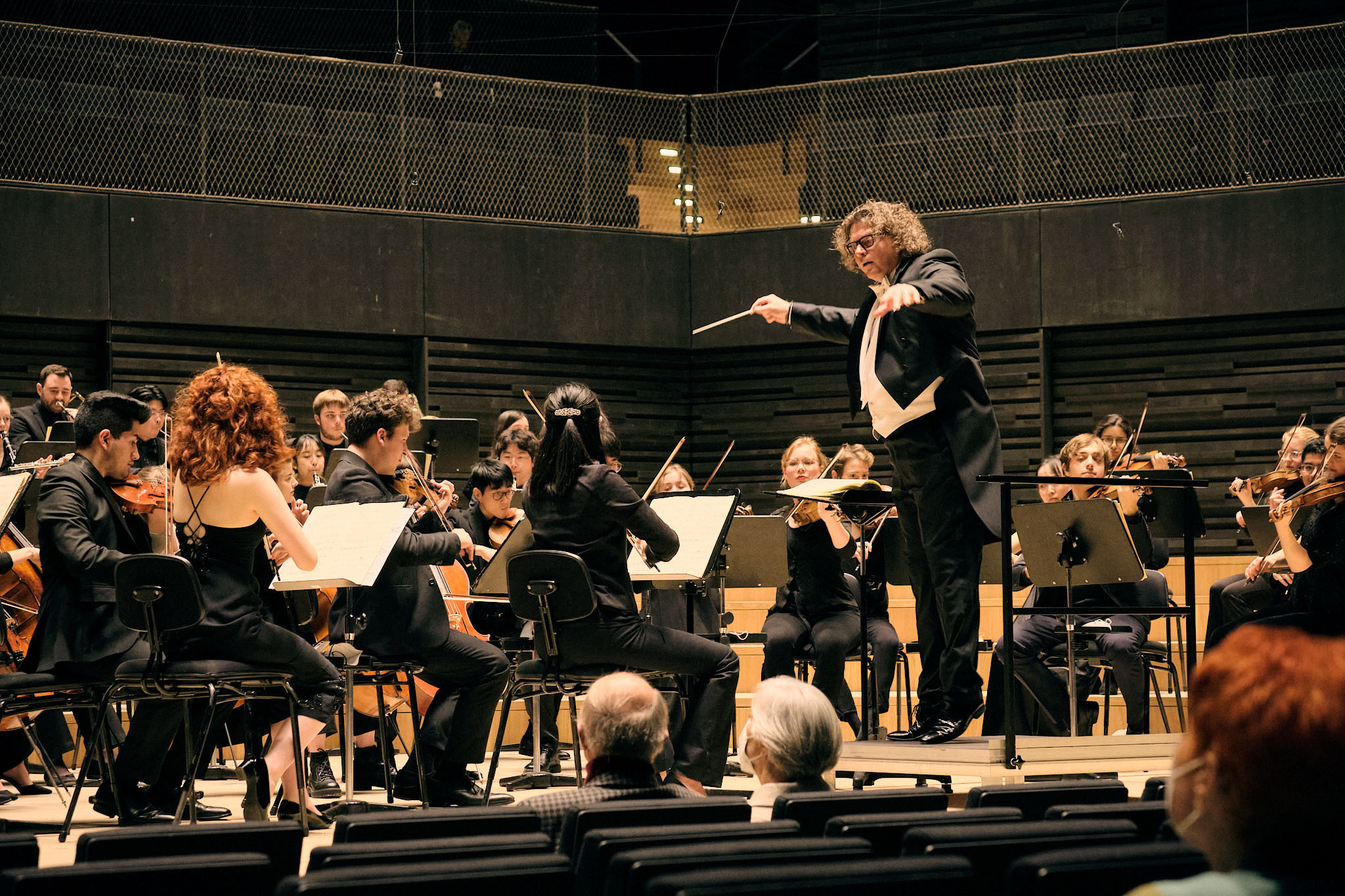 Das HSO spielt auf der Bühne der Isarphilharmonie, der Dirigent hat sich zu den ersten Geigen hingewandt.