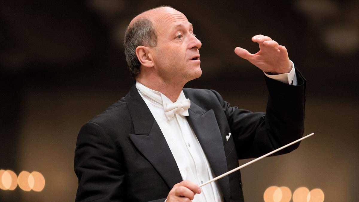 Profile shot of Iván Fischer while he is conducting.