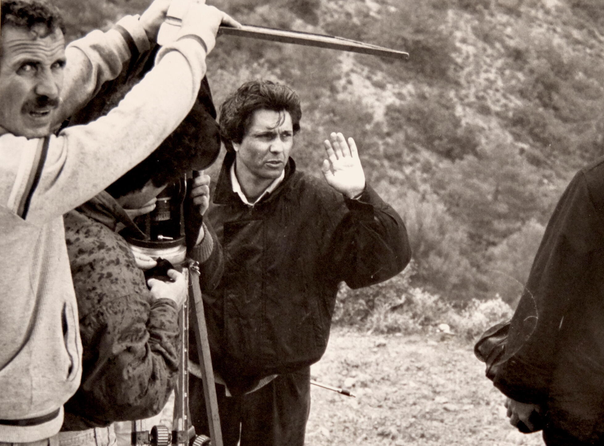 A black and white image of a camera crew shooting a film in nature.