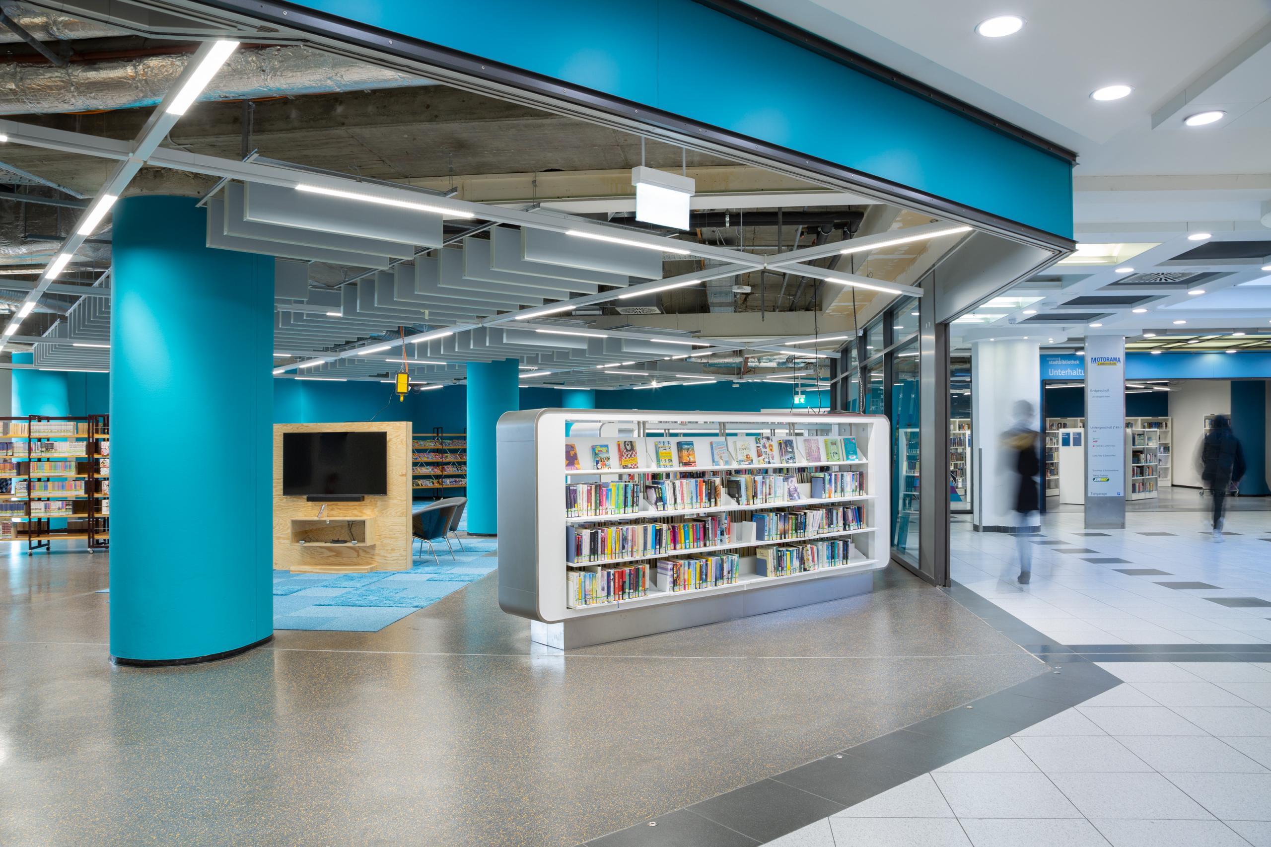 Eine Fläche in der Motorama Ladenstadt. Man sieht links den blauen Bereich der neu gestalteten Münchner Stadtbibliothek.