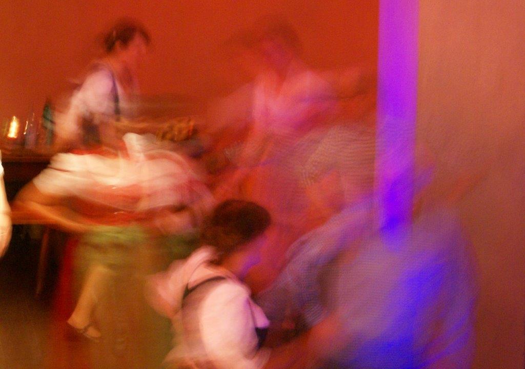 Ein in rot gehaltenes Gemälde, auf dem Menschen in einer angedeuteten Tanzbewegung zu sehen sind.