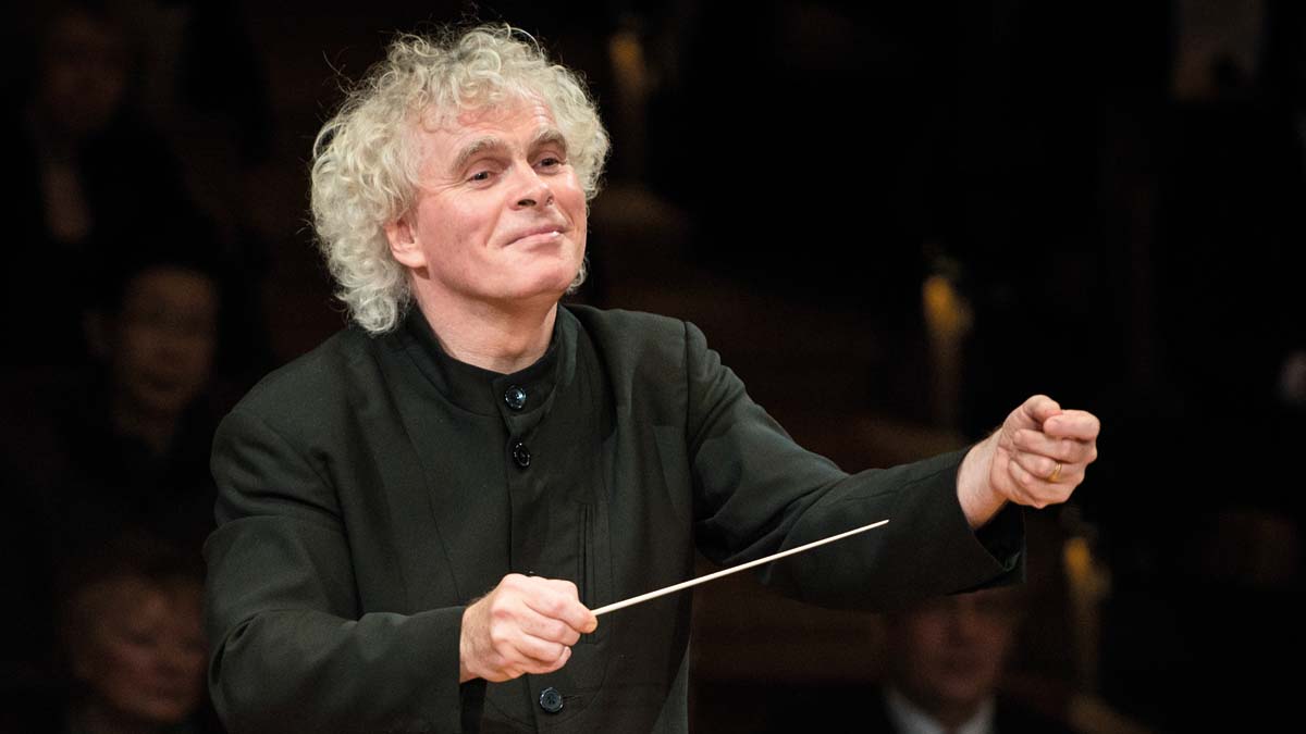 Portrait shot of Sir Simon Rattle while he conducts.