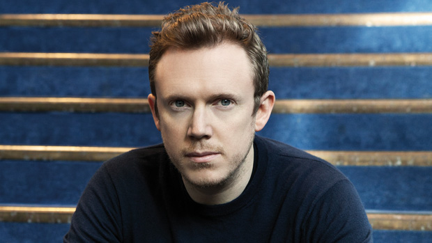 Daniel Harding sits on a blue staircase and looks into the camera.