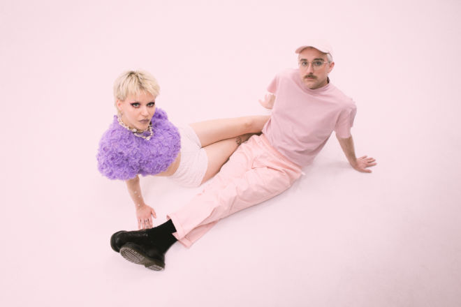 A pink-coloured floor with two people in pink outfits on it.