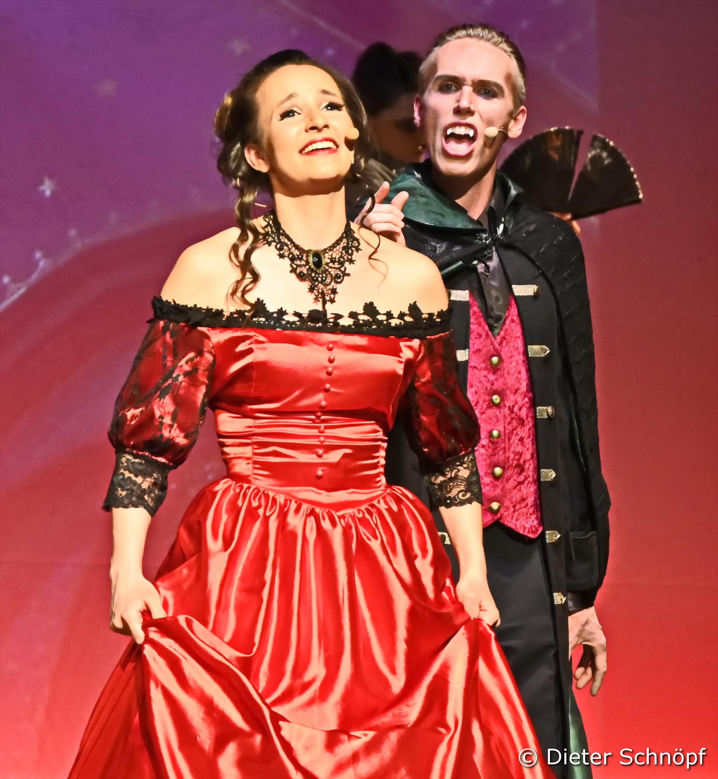 A woman and a man in vampire costumes.