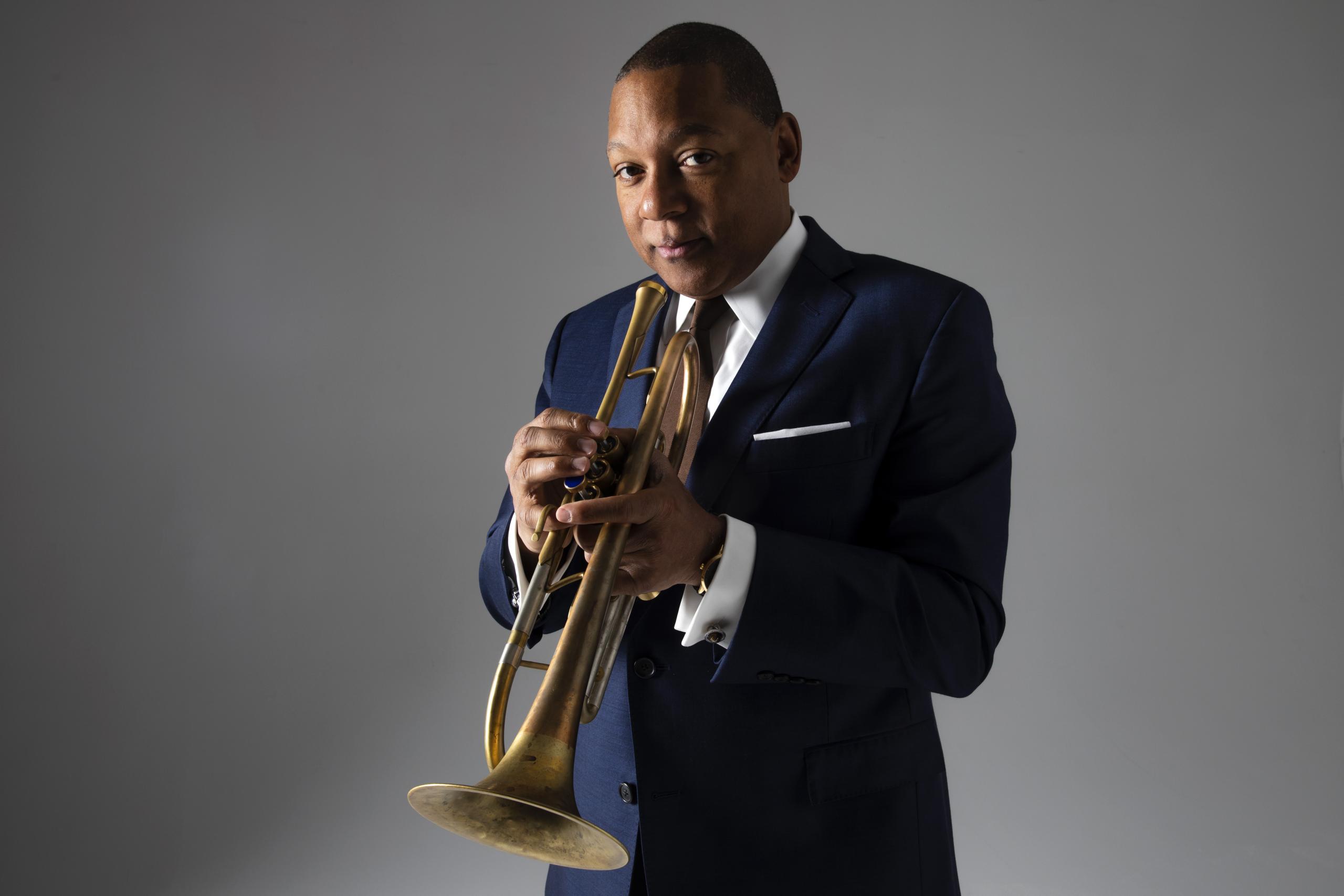 Trumpeter Marsalis with his instrument in a dark blue suit.