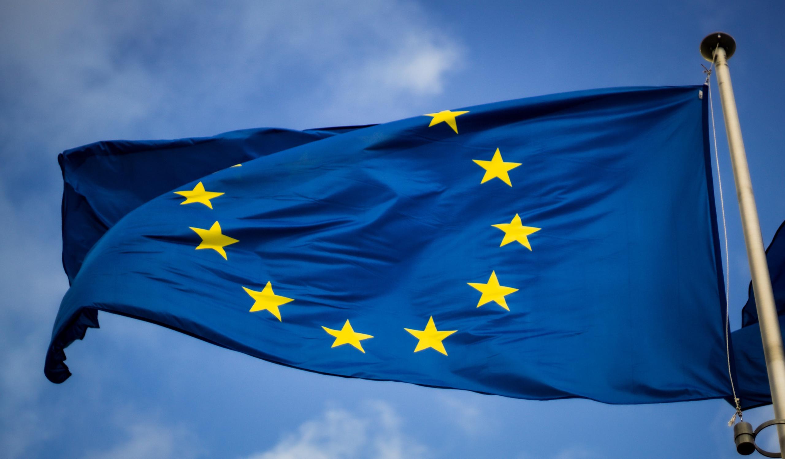 Europe flag with yellow stars on blue background fluttering in the wind