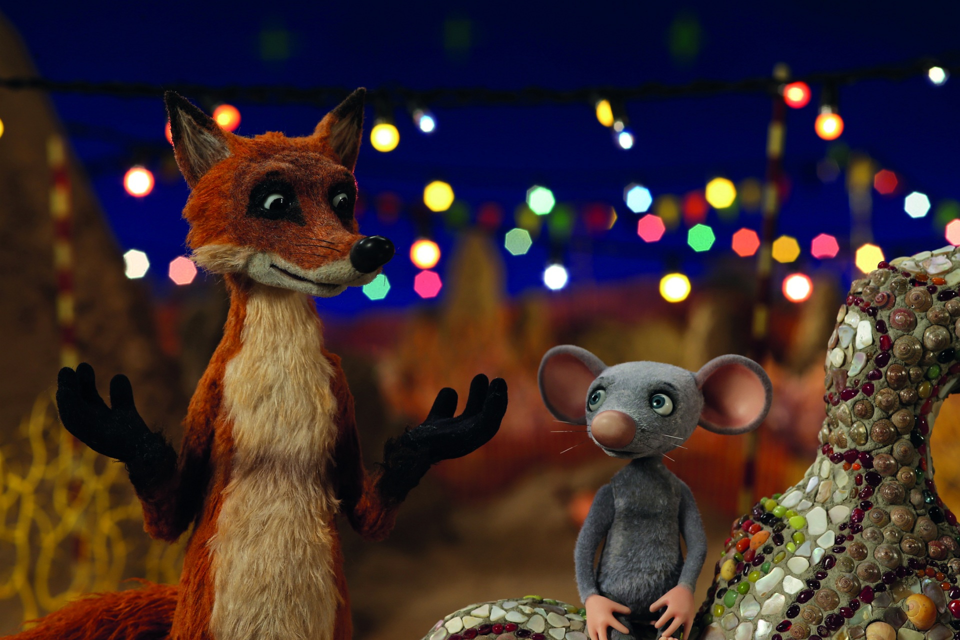 Animation von einer Maus und einem Fuchs, die in ein Gespräch sind. Im Hintergrund sieht man den Nachthimmel und bunt leuchtende Lichterketten.