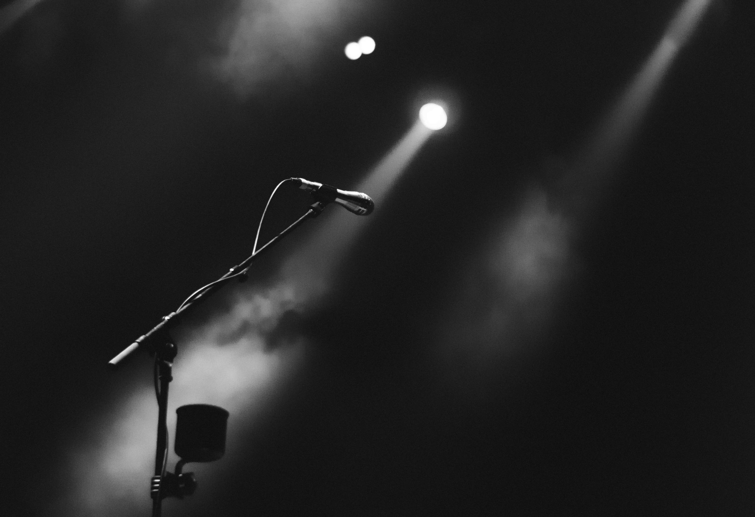 Microphone stand on empty stage in spotlight