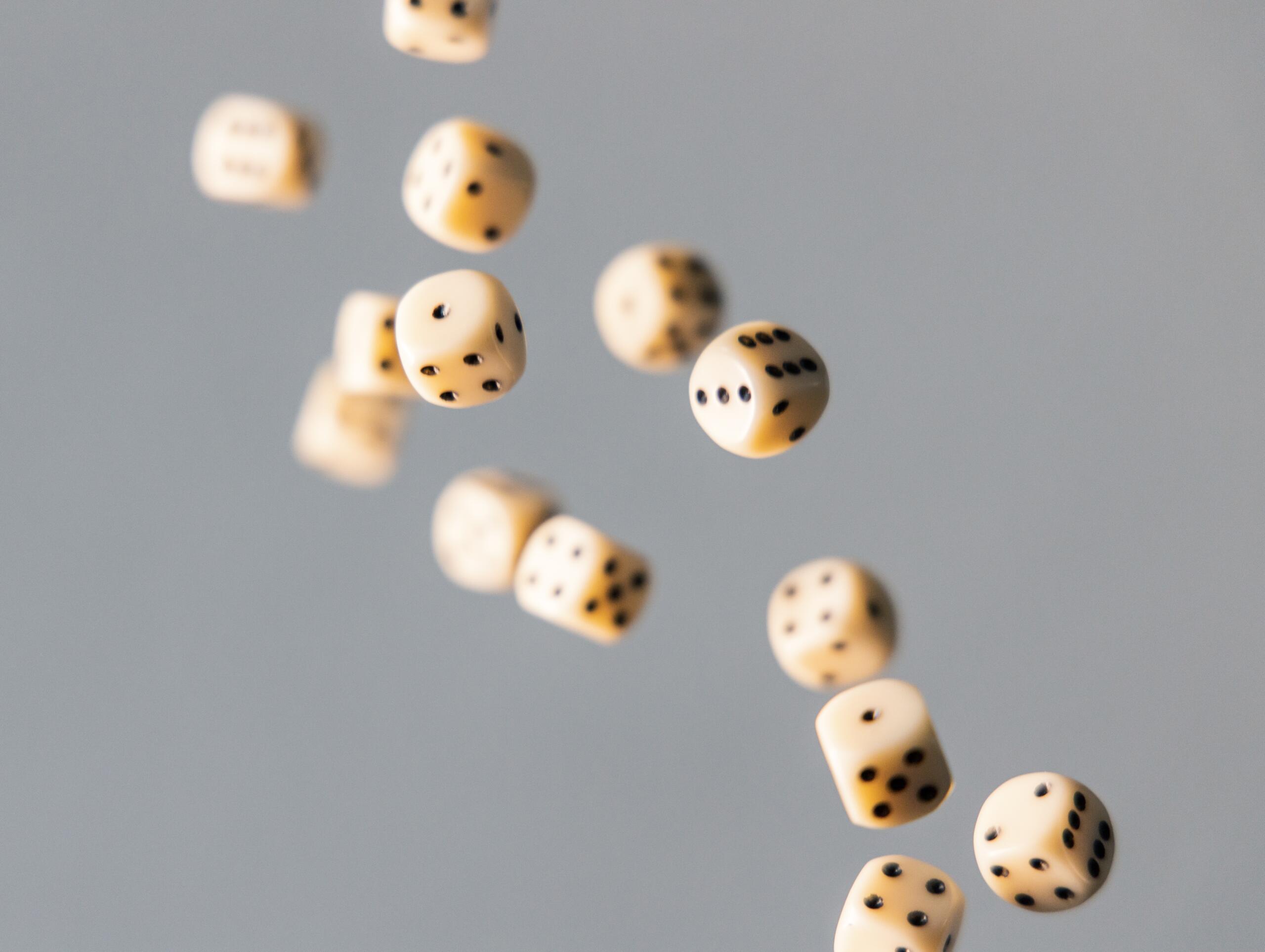 Several dices fly through the air.