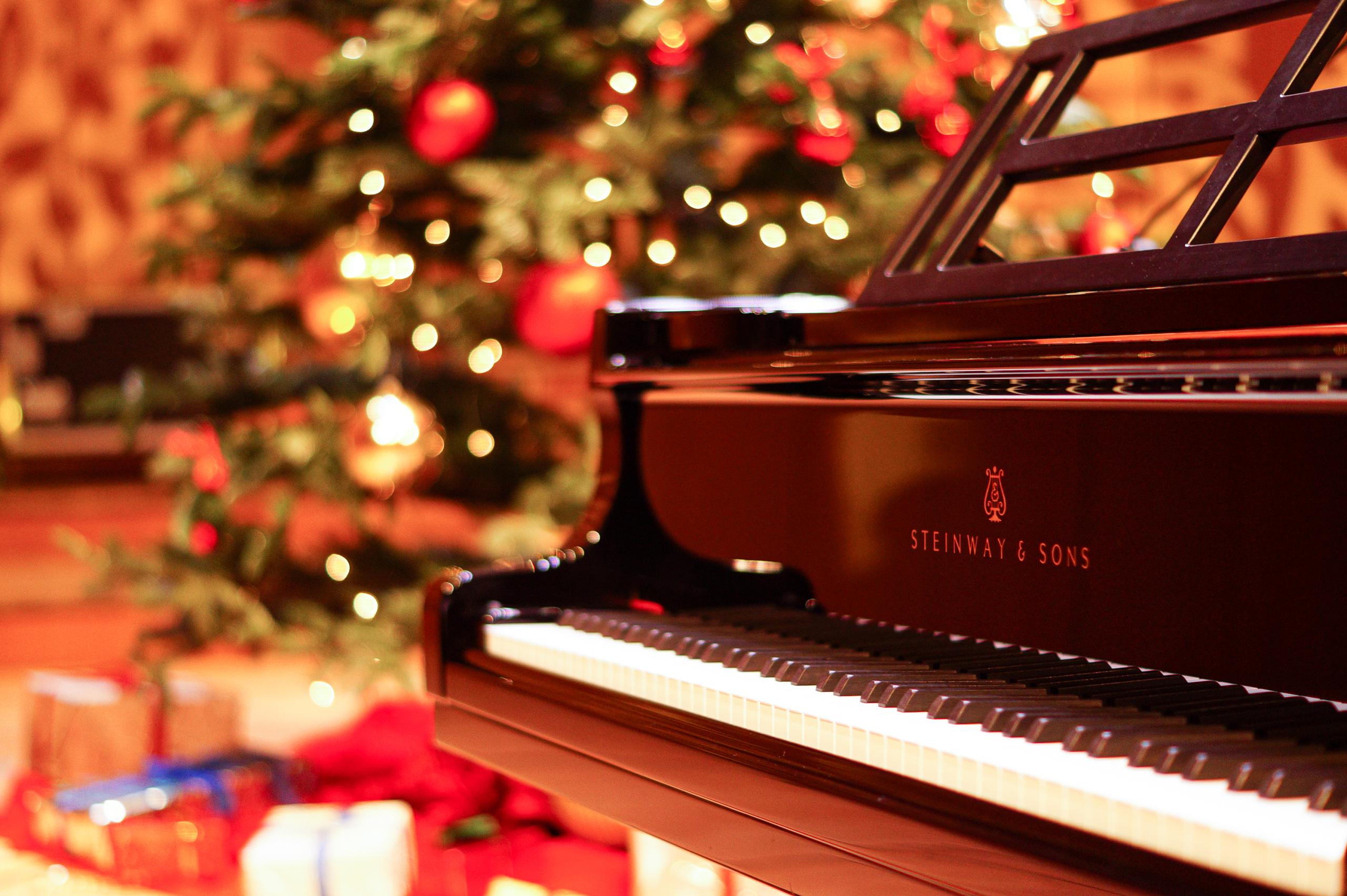 A piano, behind it a Christmas tree
